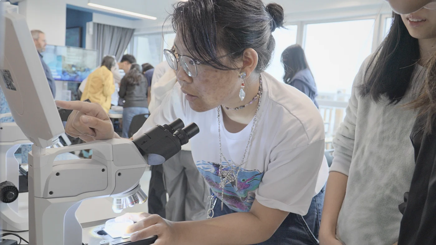 Lolan CHIU同學正透過顯微鏡，辨識她在ARMS上發現的海洋物種。