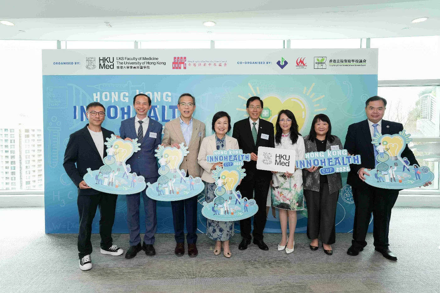Officiating guests including Professor Chak-sing Lau, Vice-President & Pro-Vice-Chancellor (Health) and Dean of Medicine of HKU (left third); Dr Choi Yuk-lin, Secretary for Education (left fourth); and Principal Lee Yi-ying, Chairman of the Hong Kong Subsidized Secondary Schools Council (right third), along with the representatives from the co-organisers.