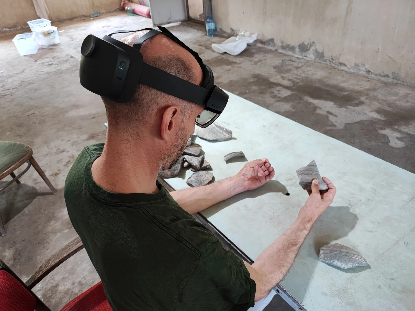 HKU Faculty of Arts Professor Peter J. Cobb compares the 3D model of a virtual pottery sherd with an adjoining real sherd. (Photo credit: HKU Faculty of Arts)